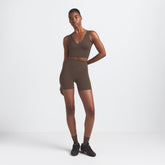 NikeSKIMS MATTE V-NECK BRA TOP | DARK SEPIA ON A MODEL FRONT VIEW @ | FOCUS: 0.9, 0.1, 0.7