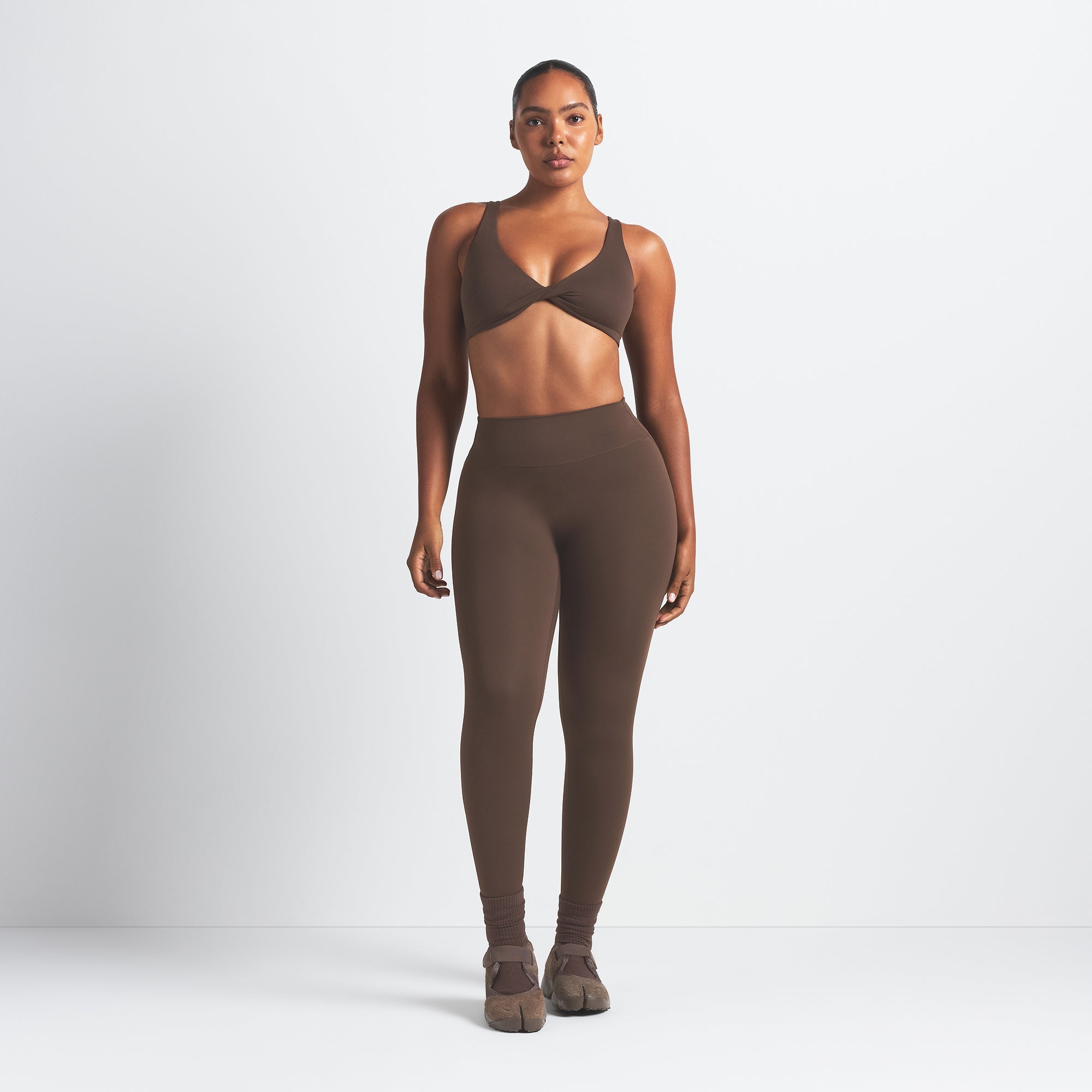 NikeSKIMS MATTE 26" LEGGING | DARK SEPIA ON A MODEL FRONT VIEW @ | FOCUS: 0.9, 0.1, 0.7