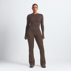 NikeSKIMS MATTE SLIM FLARE LEGGING | DARK SEPIA ON A MODEL FRONT VIEW