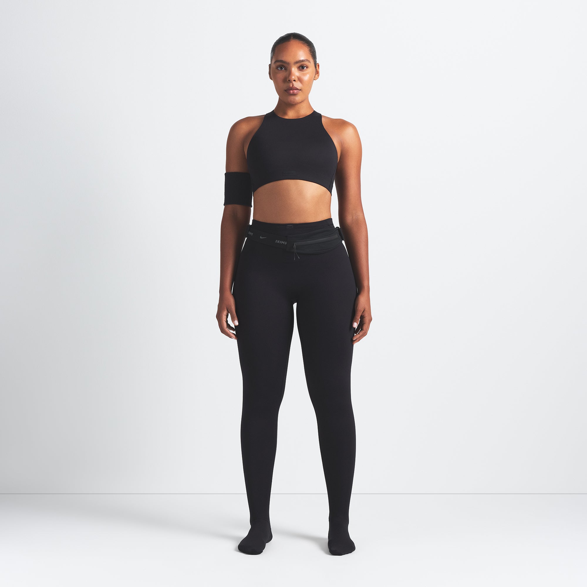NikeSKIMS MATTE HIGH NECK BRA | OBSIDIAN ON A MODEL FRONT VIEW @ | FOCUS: 0.9, 0.1, 0.7
