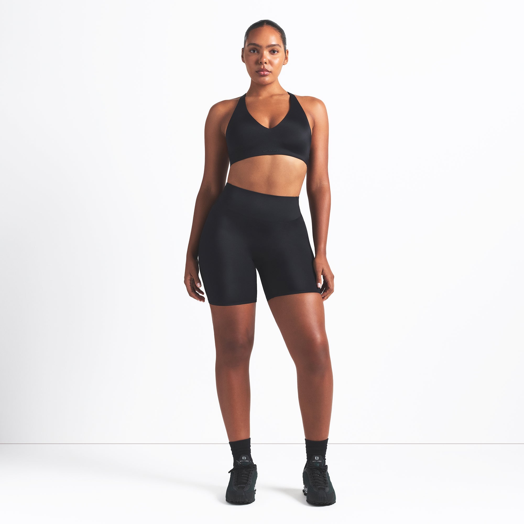 NikeSKIMS SHINE BONDED WAIST 5" BIKER SHORT | OBSIDIAN ON A MODEL FRONT VIEW @ | FOCUS: 0.9, 0.1, 0.7