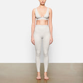 A MODEL STANDS FACING FORWARD WEARING THE COTTON RIB LEGGING | LIGHT HEATHER GREY