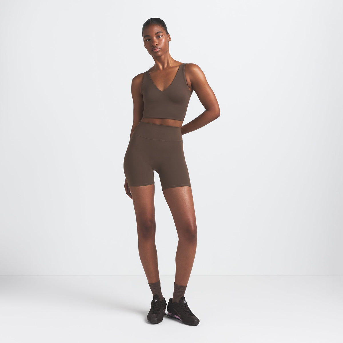 NikeSKIMS MATTE V-NECK BRA TOP | DARK SEPIA ON A MODEL FRONT VIEW @ | FOCUS: 0.9, 0.1, 0.7