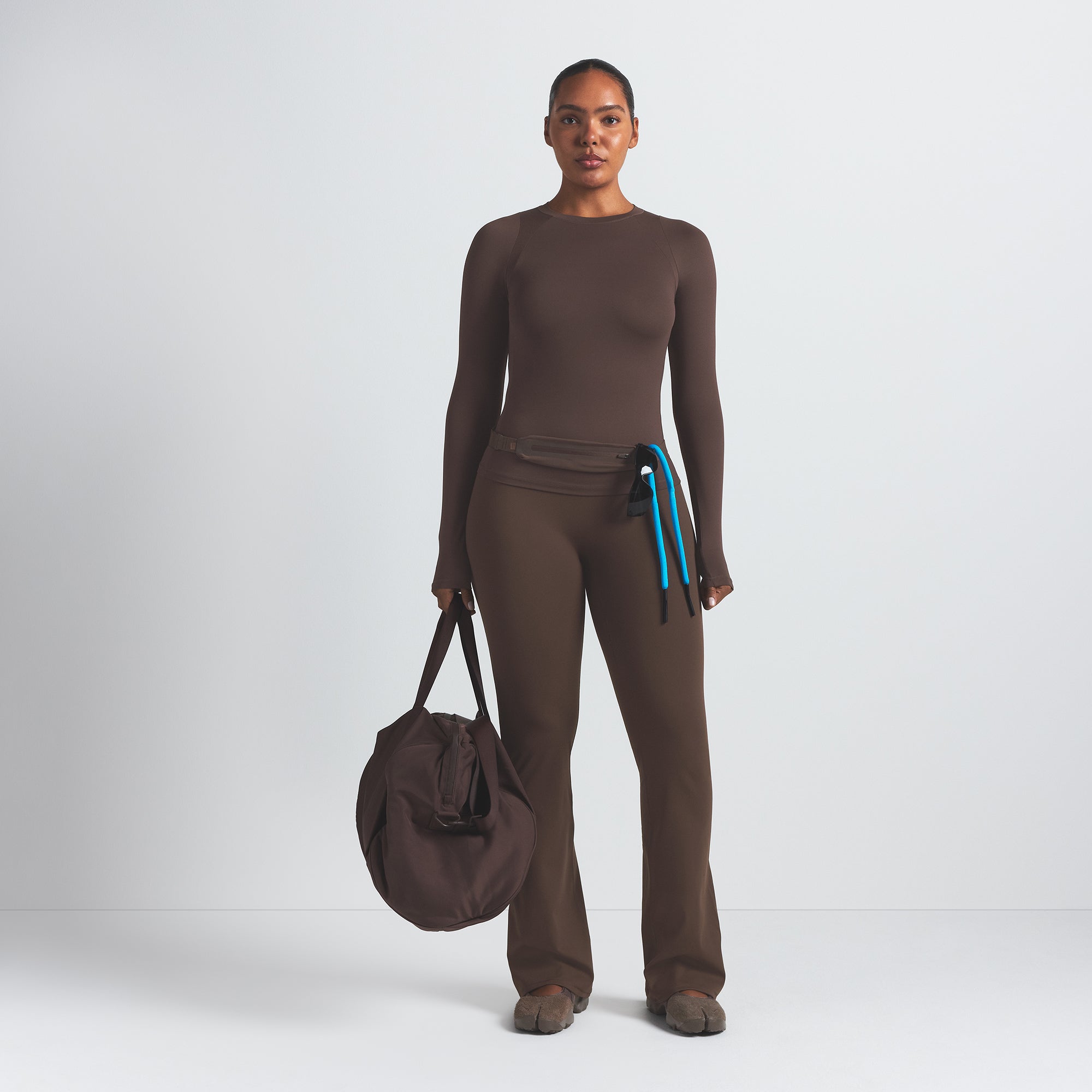 NikeSKIMS MATTE SLIM FLARE LEGGING | DARK SEPIA ON A MODEL FRONT VIEW @ | FOCUS: 0.9, 0.1, 0.7