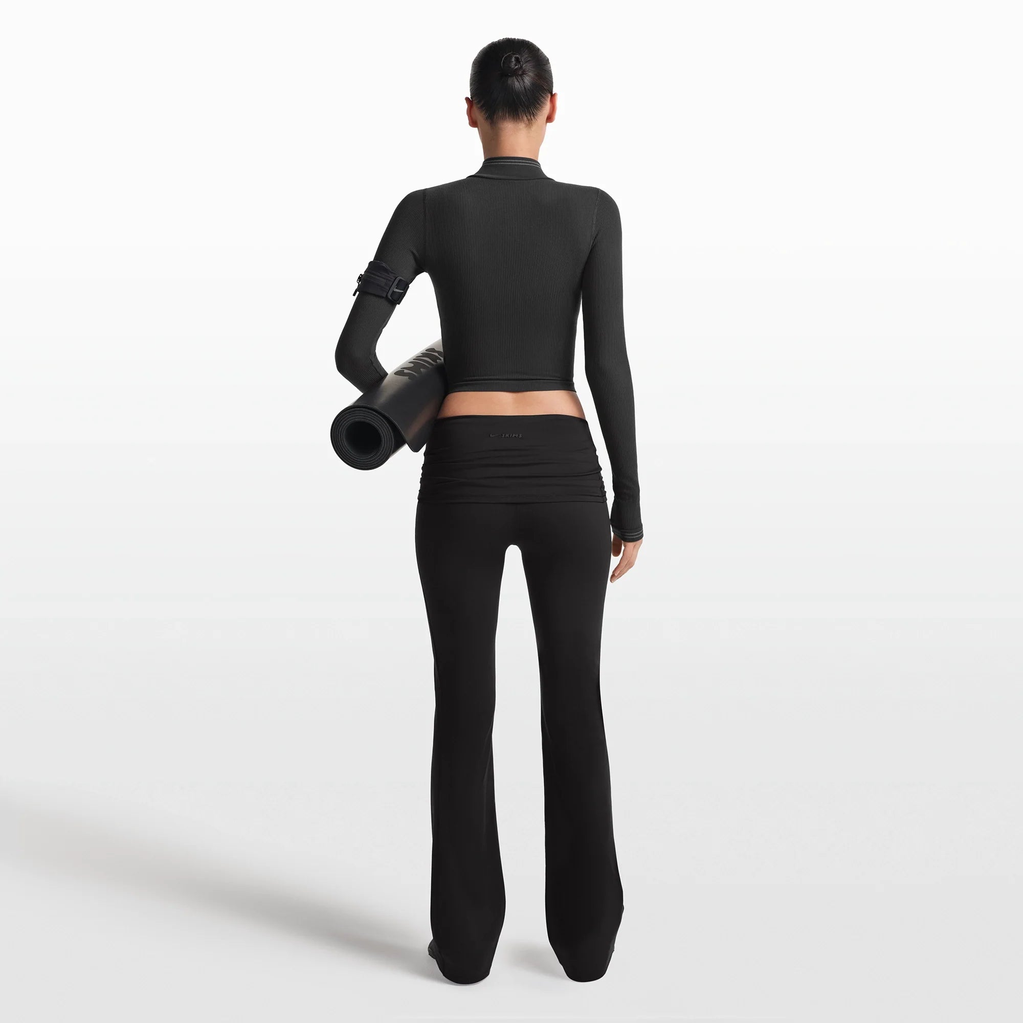 NikeSKIMS MATTE FOLDOVER SLIM FLARE LEGGING | OBSIDIAN ON A MODEL FRONT VIEW @ | FOCUS: 0.0, 1.0, 0.9