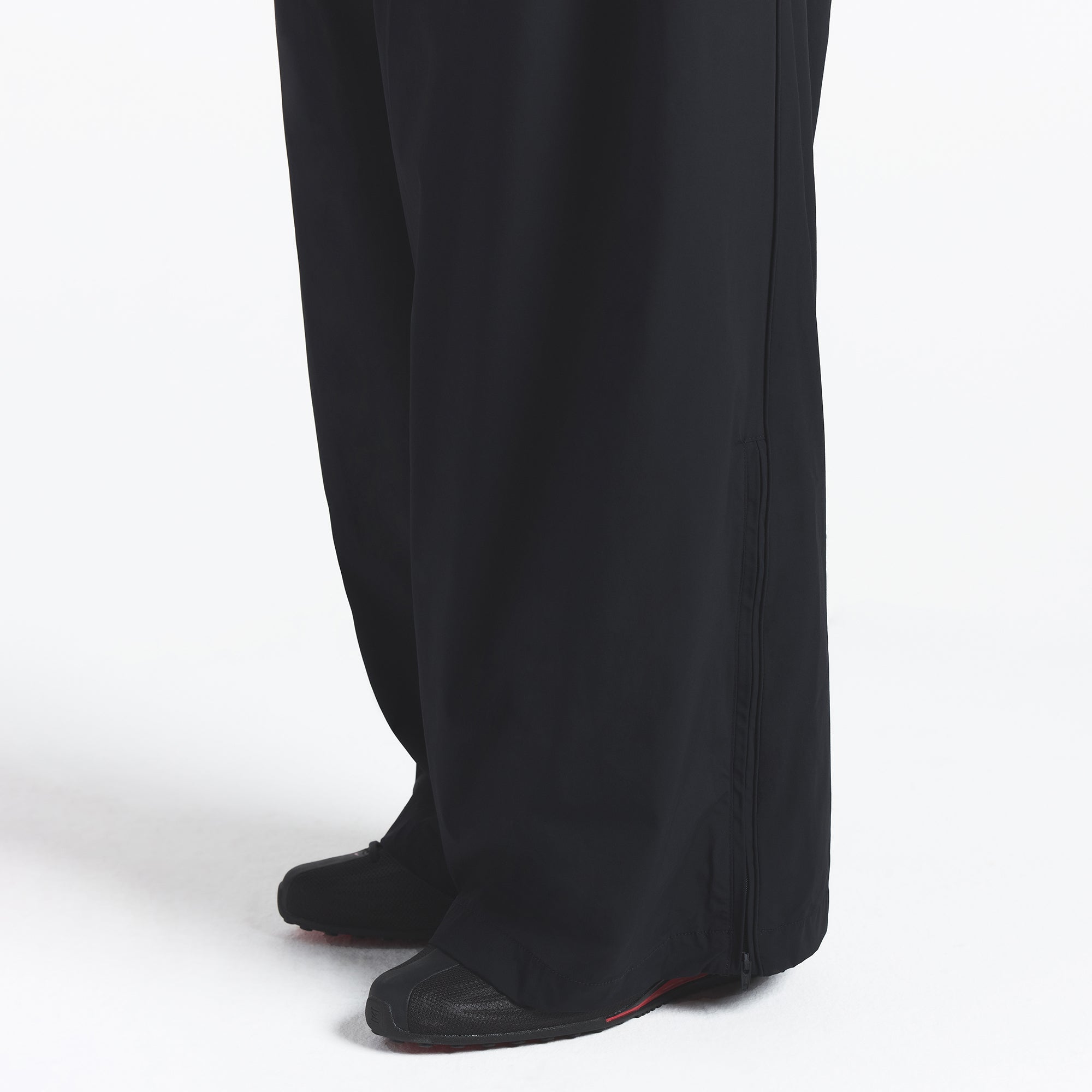 NikeSKIMS WOVEN NYLON OVERSIZED TRACK PANT | OBSIDIAN ON A MODEL SIDE VIEW @ | FOCUS: 0.0, 1.0, 0.9
