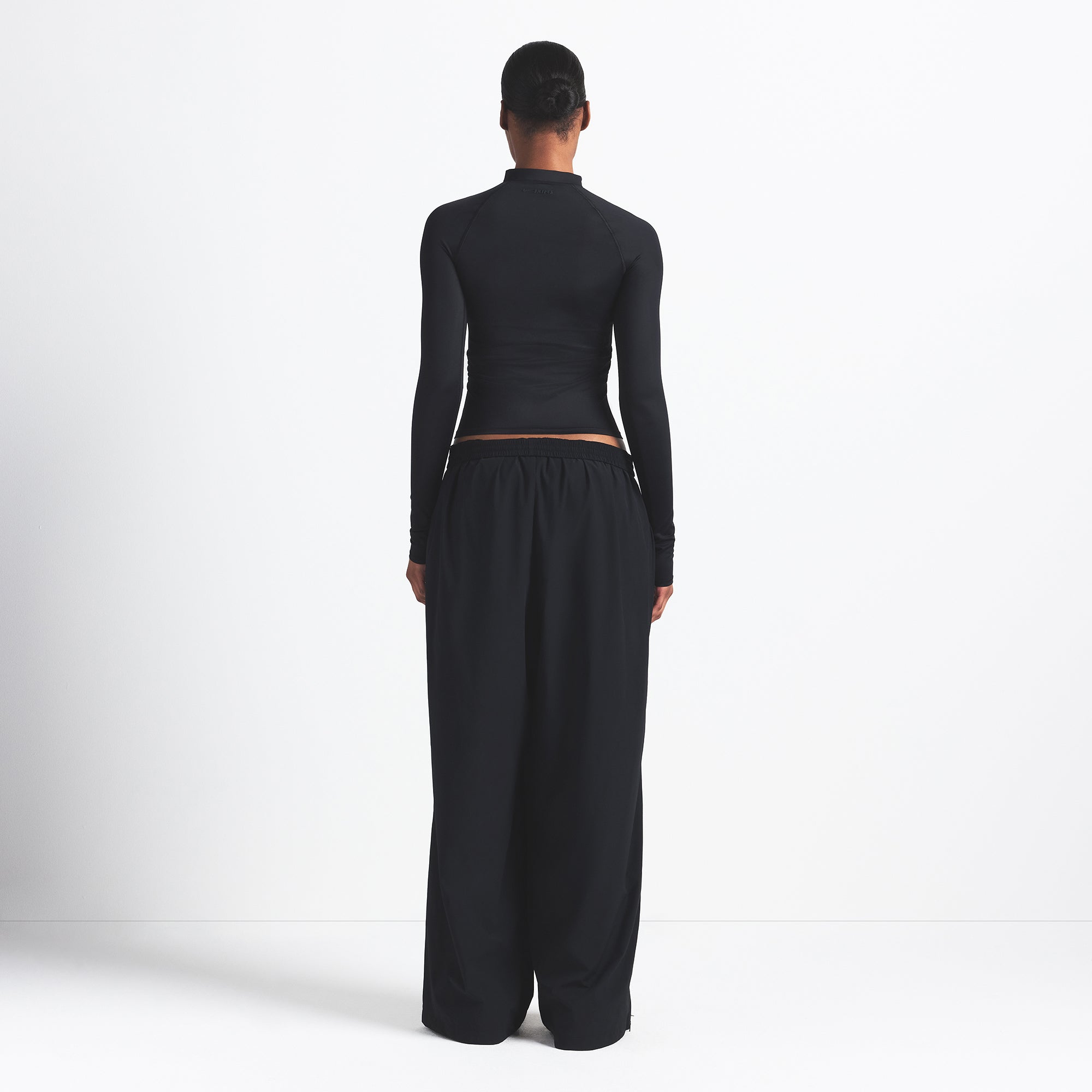 NikeSKIMS WOVEN NYLON OVERSIZED TRACK PANT | OBSIDIAN ON A MODEL BACK VIEW @ | FOCUS: 0.0, 1.0, 0.9