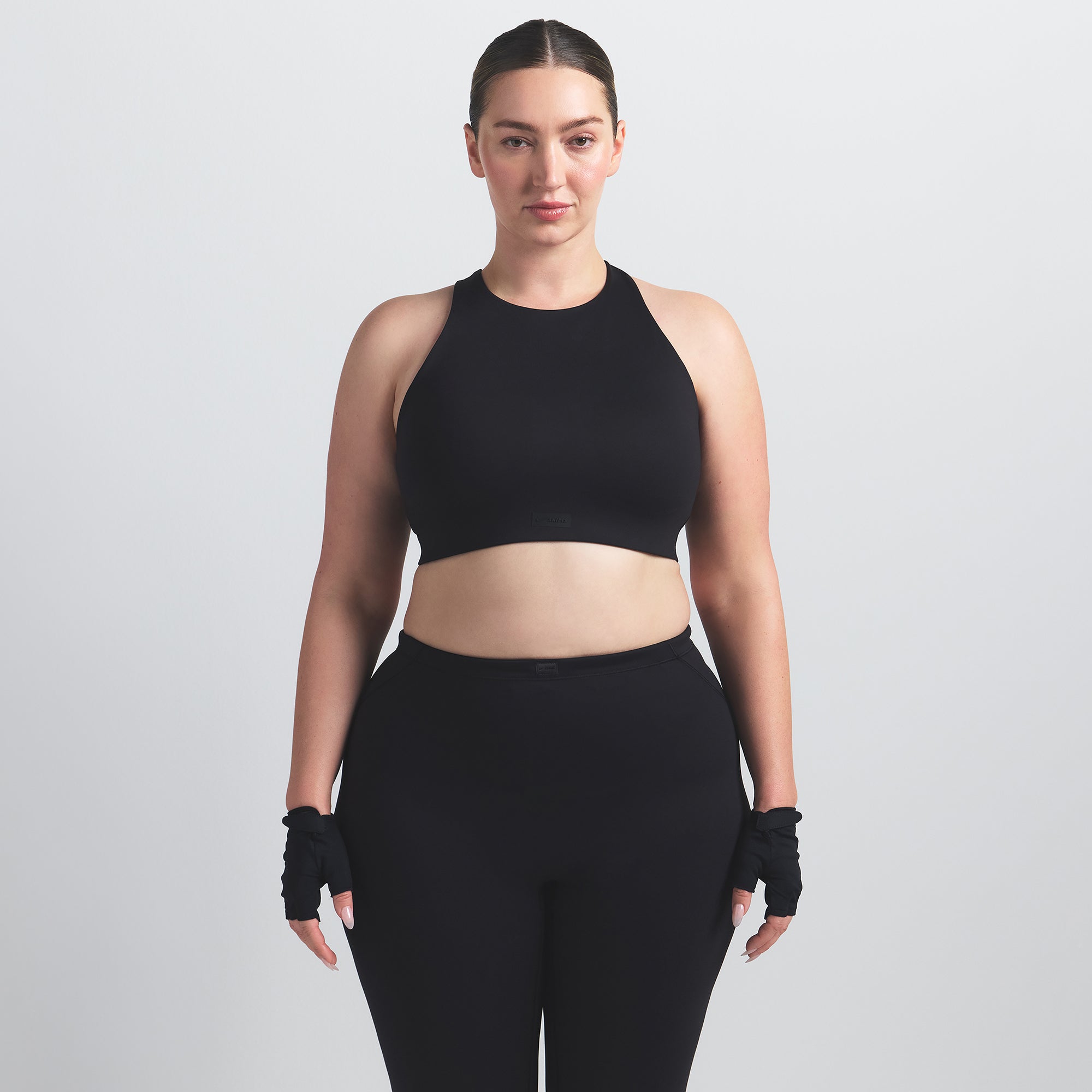 NikeSKIMS MATTE HIGH NECK BRA | OBSIDIAN ON A MODEL FRONT VIEW