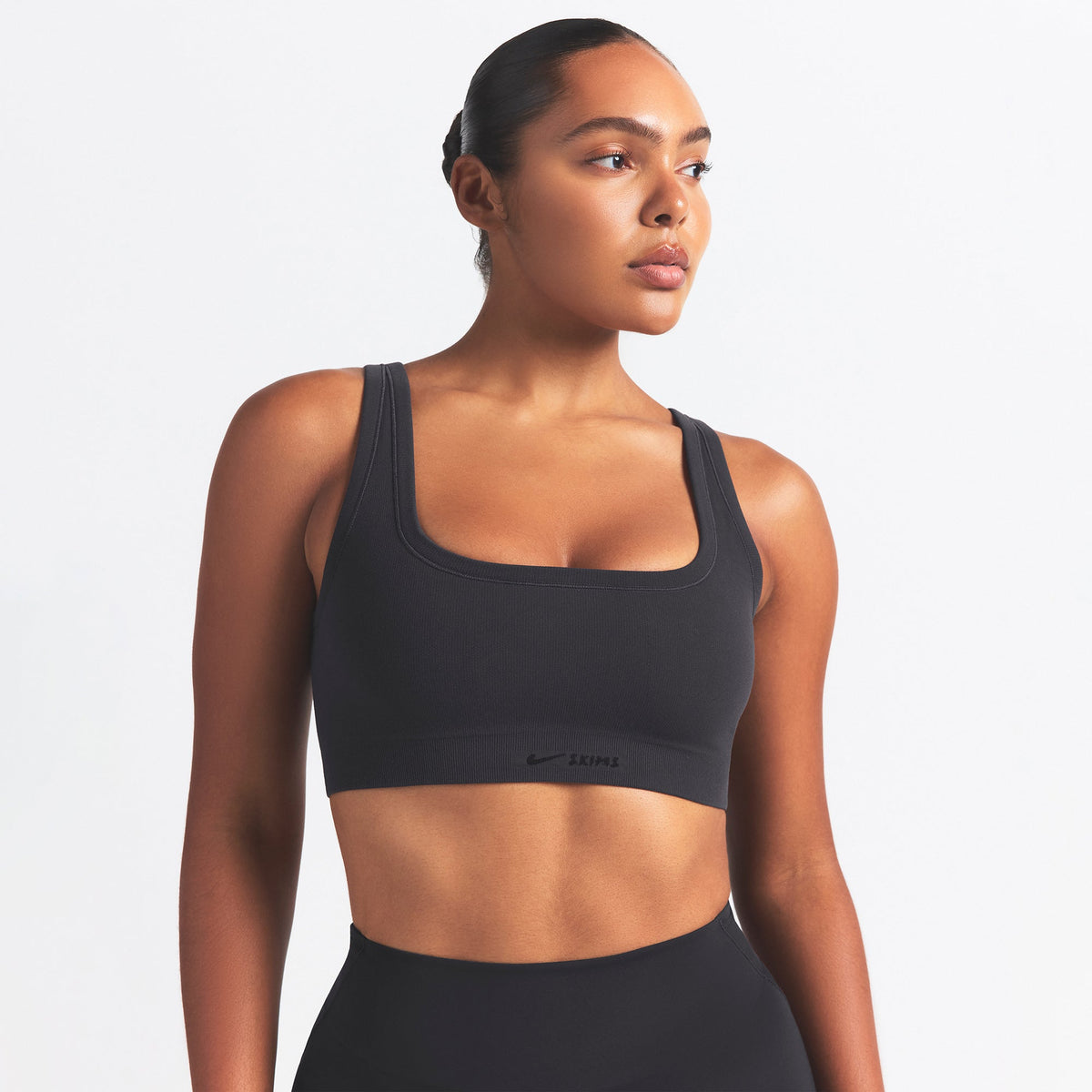 NikeSKIMS VINTAGE SEAMLESS SCOOP NECK BRA | OBSIDIAN ON A MODEL SIDE VIEW @ | FOCUS: 0.9, 0.1, 0.7