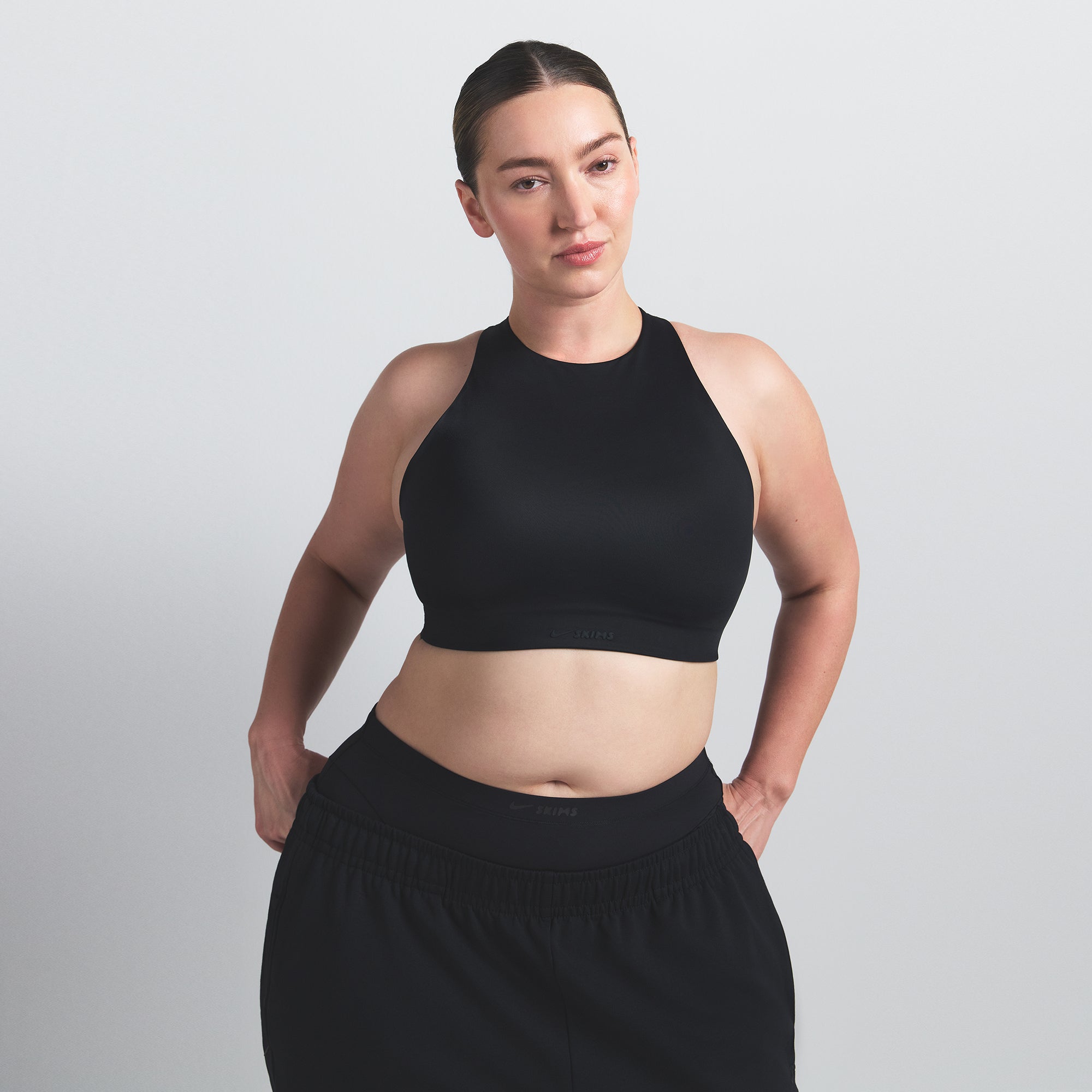 NikeSKIMS SHINE HIGH NECK BRA | OBSIDIAN ON A MODEL SIDE VIEW