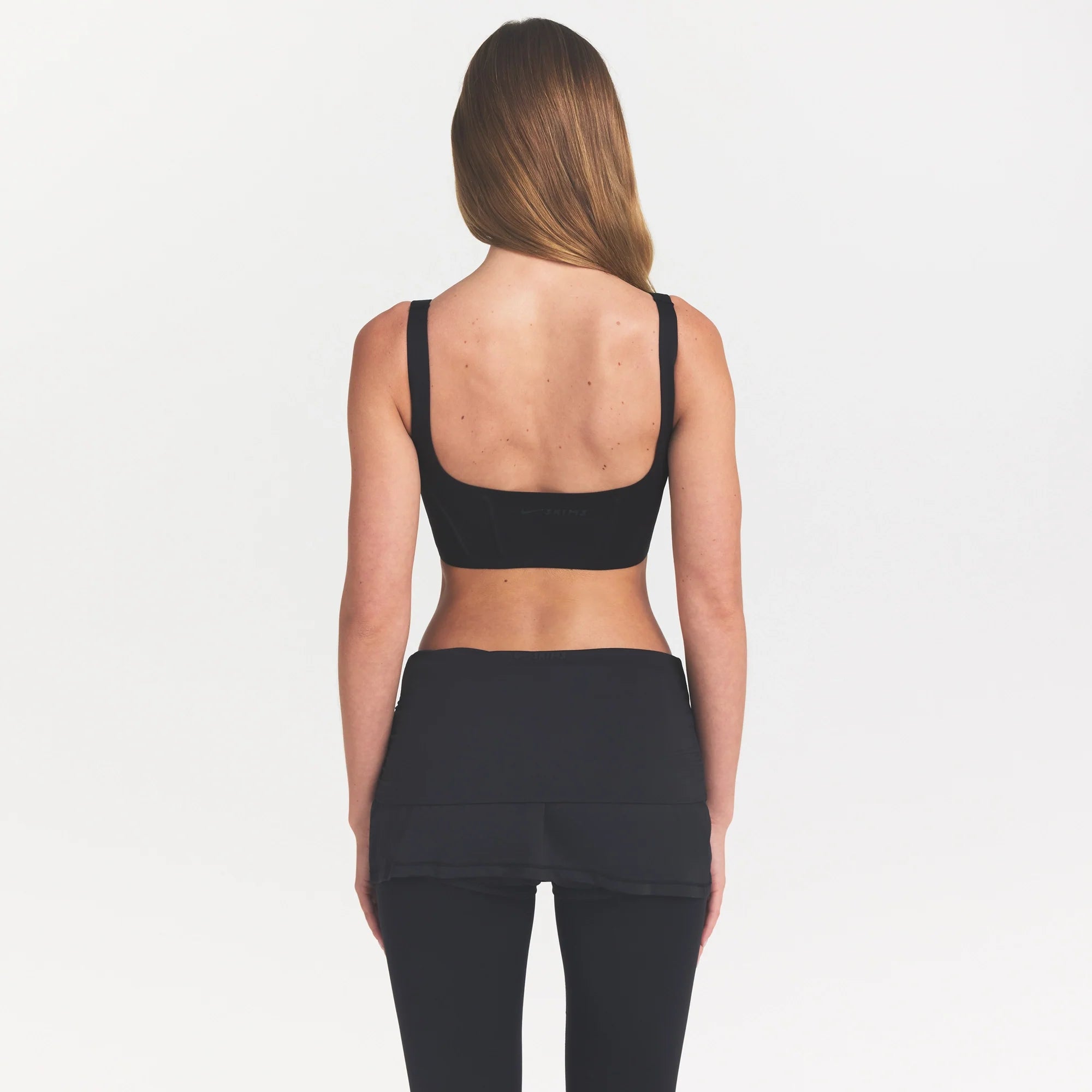 NikeSKIMS MATTE CORSET LONGLINE BRA | OBSIDIAN ON A MODEL