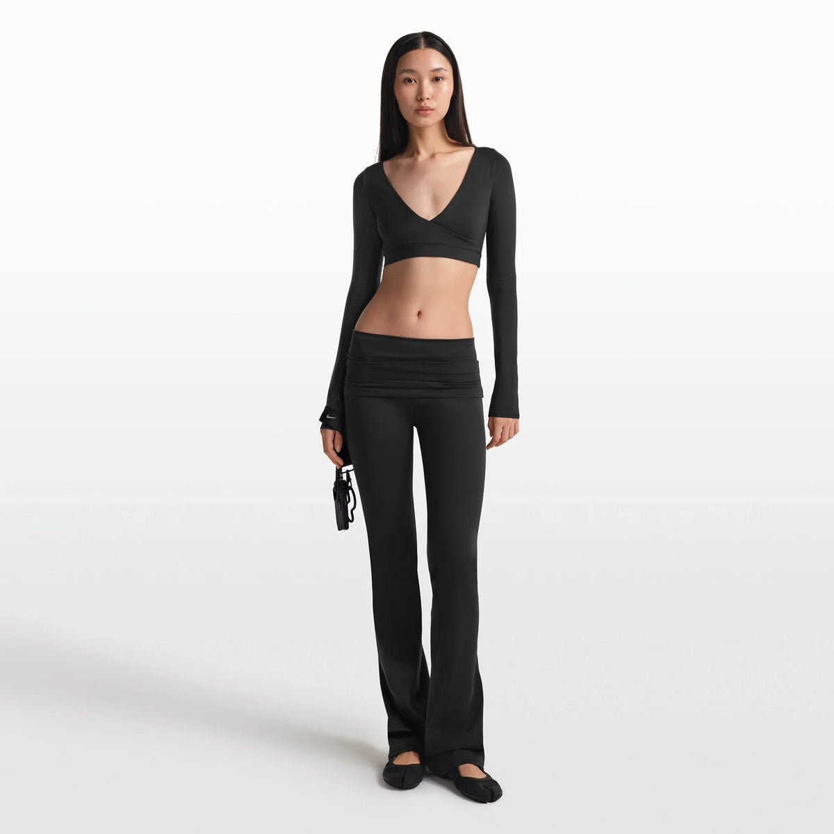 NikeSKIMS MATTE WRAP LONG SLEEVE CROPPED TOP | OBSIDIAN ON A MODEL FRONT VIEW @ | FOCUS: 0.0, 1.0, 0.9