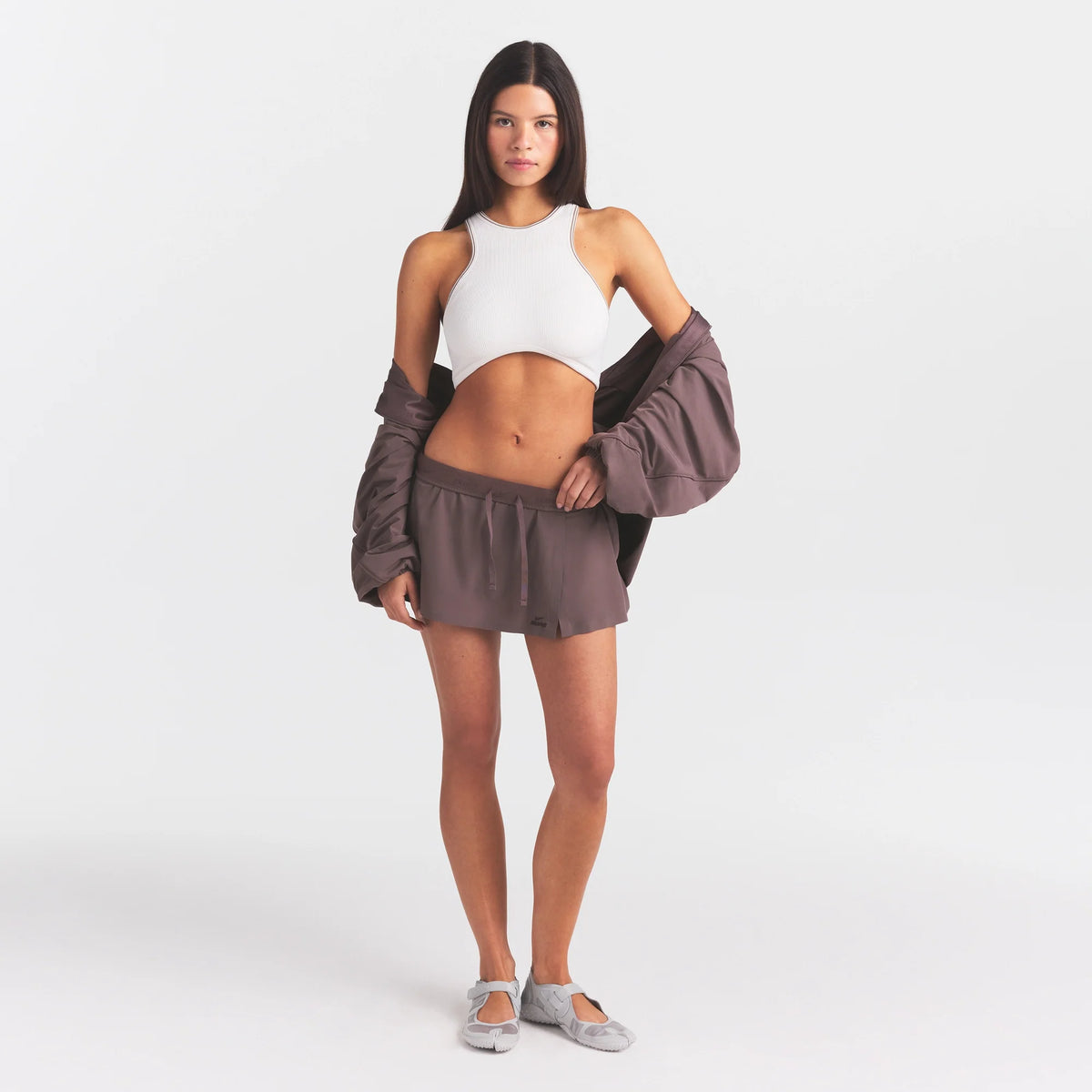 NikeSKIMS STRETCH NYLON SKORT | RESIN ON A MODEL FRONT VIEW @ | FOCUS: 0.0, 1.0, 0.9