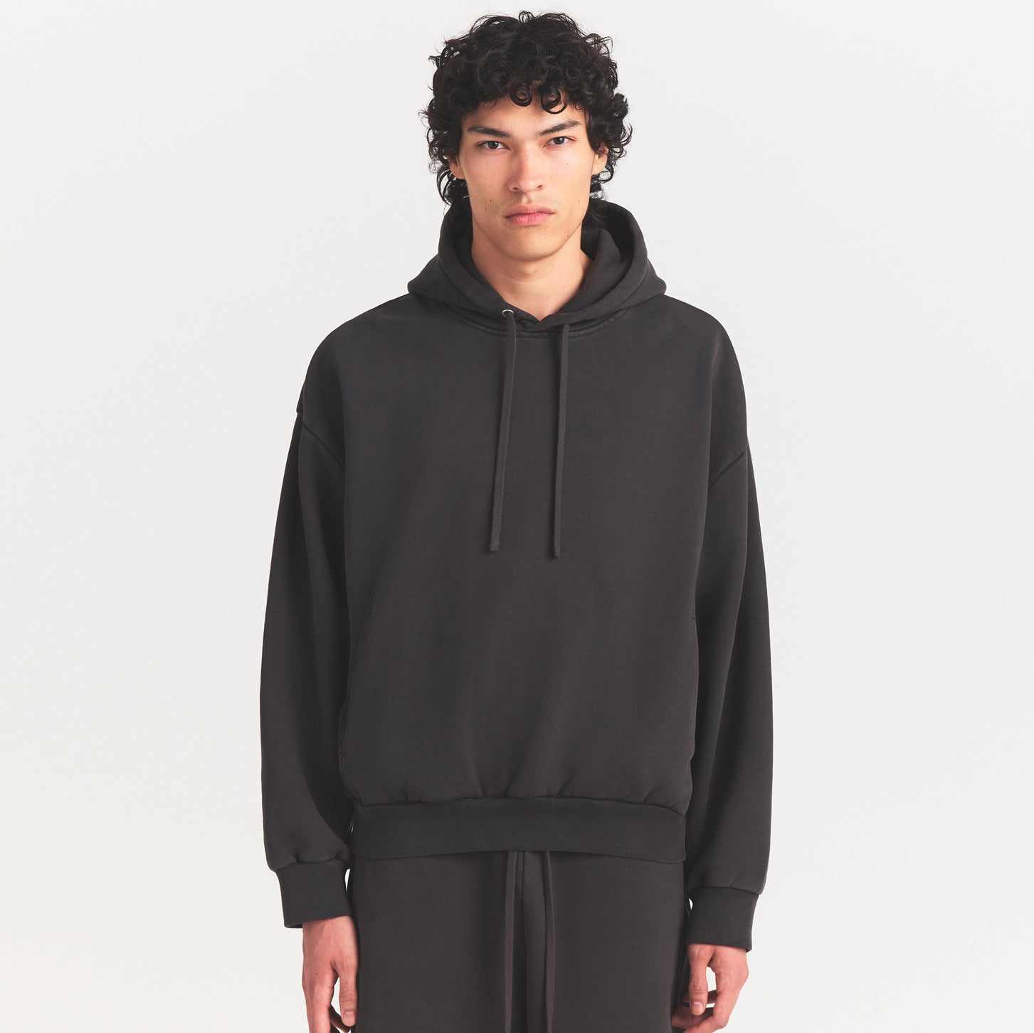 HEAVYWEIGHT FLEECE MENS HOODIE | WASHED ONYX ON A MODEL SIDE VIEW @ | FOCUS: 0.0, 1.0, 0.9