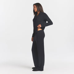 SKIMS SLEEP LONG SLEEVE BUTTON UP SET | ONYX ON A MODEL SIDE VIEW @ | FOCUS: 0.0, 1.0, 0.9