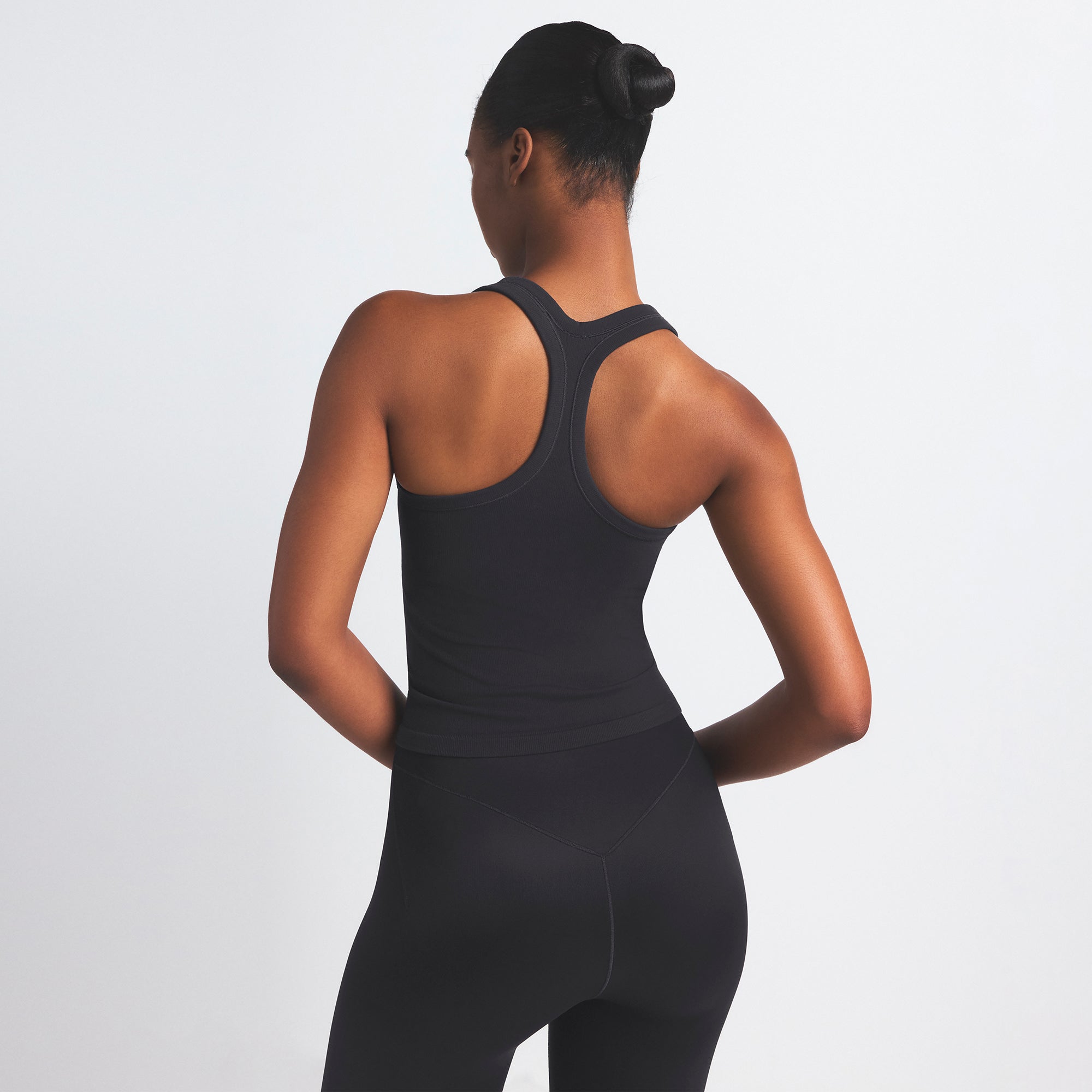 NikeSKIMS VINTAGE SEAMLESS RACER BACK TANK | OBSIDIAN ON A MODEL SIDE VIEW @ | FOCUS: 0.9, 0.1, 0.7